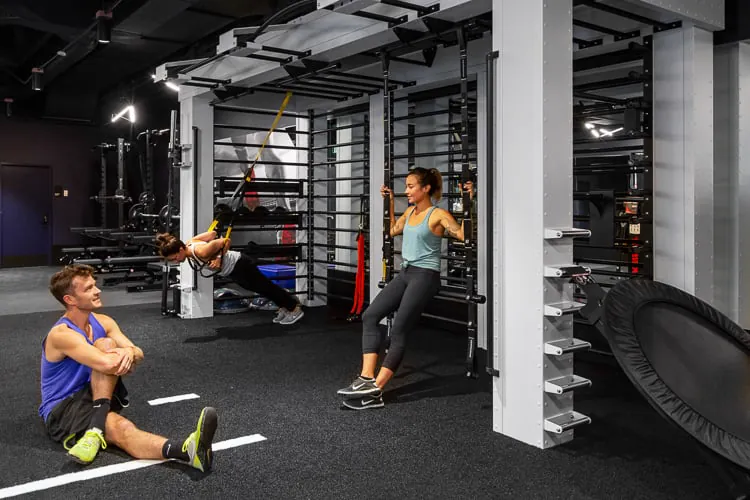Zaposleni koriste modularnu opremu za trening u fitnes prostoru visokih performansi dizajniranom za funkcionalno kretanje.