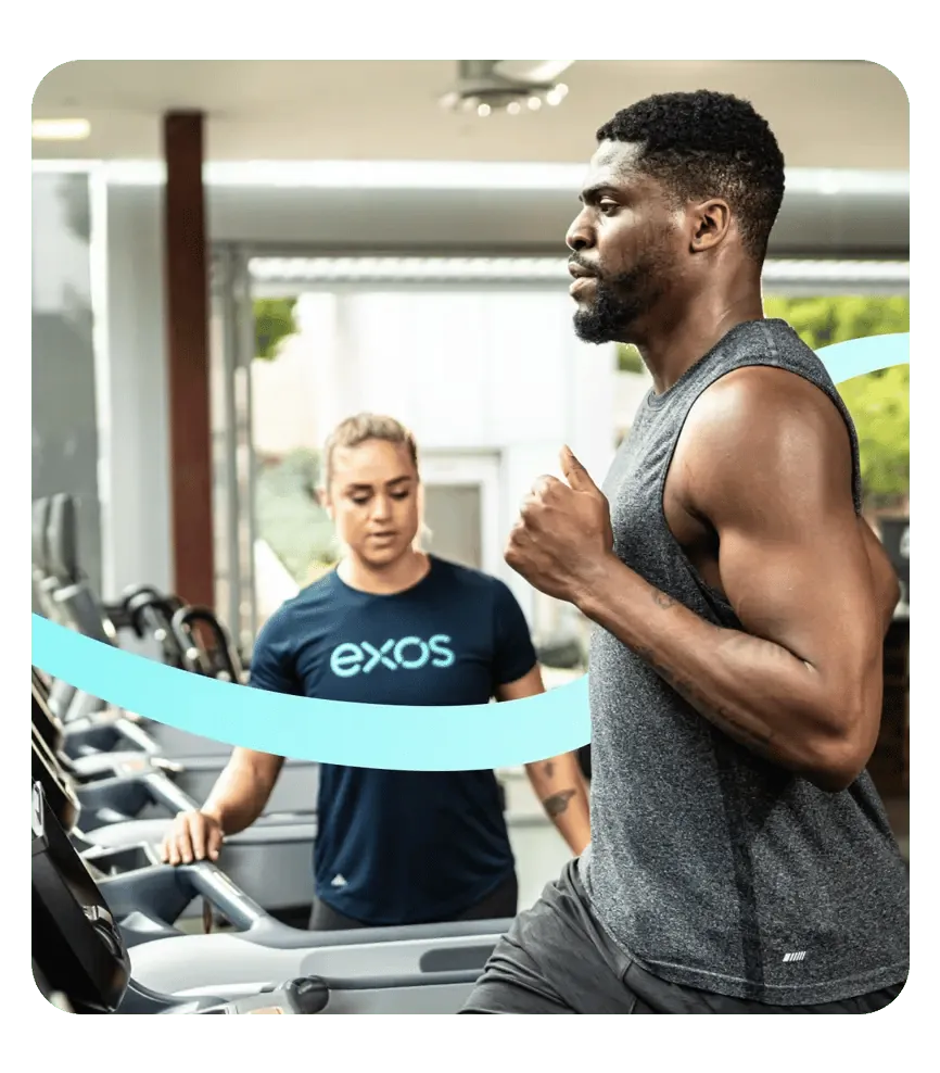 Exos trener vodi zaposlenog kroz personalizovani trening na traci u objektu za blagostanje.