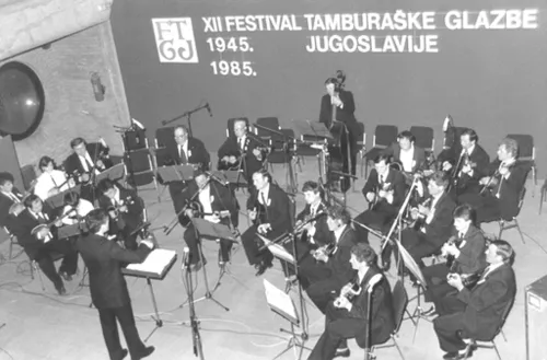Tamburaški orkestar u Osijeku 1985. godine. S leva na desno: Antun Matešić, Valentina Šikeždi, Nikoa Markus, Mario Pavlić, Suzana Hvala, Željko Gajger, primaši. Miroslav Mikulinac, Antun Matešić i Marko Grubišić prvi bas prim, Ivan Rakoš, Miroslav Giner, Josip Rakoš i Ivan Horvatić drugi bsa prim, Miroslav Benčić i Kazimir Lanc treći bas prim, Mihajlo Kun i Andrija Gajger čelo, Tomislav Gajger i Đura Šikeždi kontre, Paja Rakoš bas, dirigent Boško Bogičević