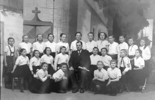 Hor 1954. godine. S leva na desno čuče: Nevenka Šikeždi Veronika Matešić, Nikolina Štimac i Zdenka Bodor. Sede: Ruža Varga, Anica Švab, Katica Lanc, Mara Pitok, Đura Kun-Lala horovođa, Helena Varga, Kata Štimac, Sofija Rakoš i Nikolina Pil. Stoje: Blaženka Matešić, Ruža Šikeždi, Blaženka Bodor, Agica Bodor, Slavivca Palajić, Ana Pil, Blaženka Rakoš, Marijana ?, Eva Kun, Lela Juričić, Zdenka Bodor i Katica Nagl.